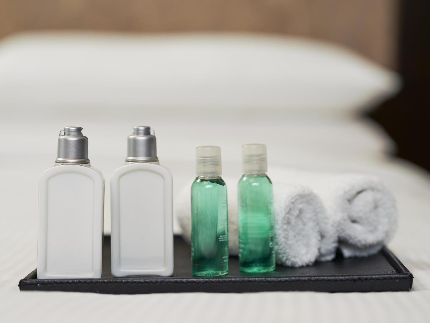  A tray with shampoo, conditioner, and soap bottles neatly arranged.