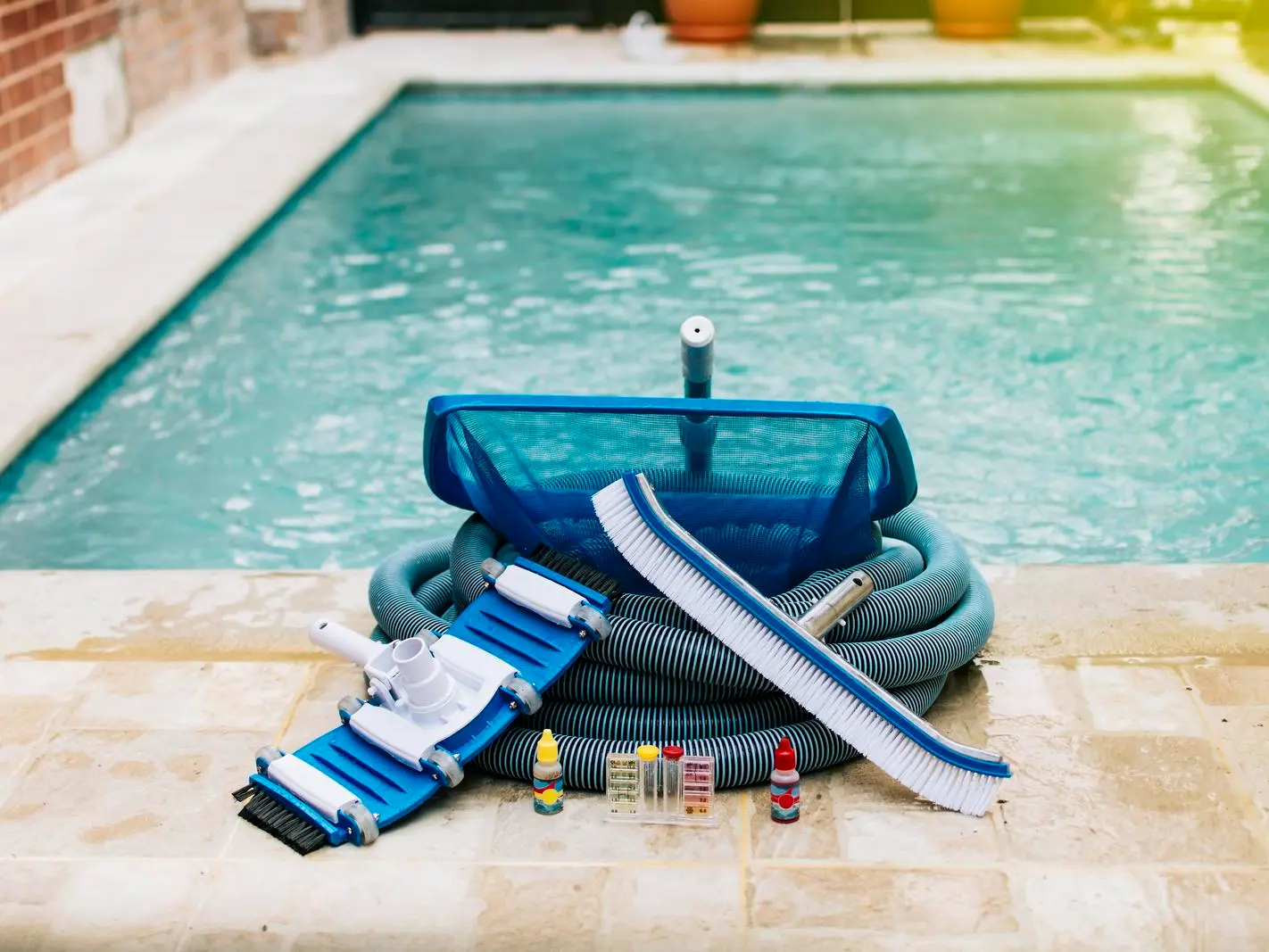 Pool maintenance equipment and accessories: brushes, nets, vacuum heads, chemicals, and test kits.