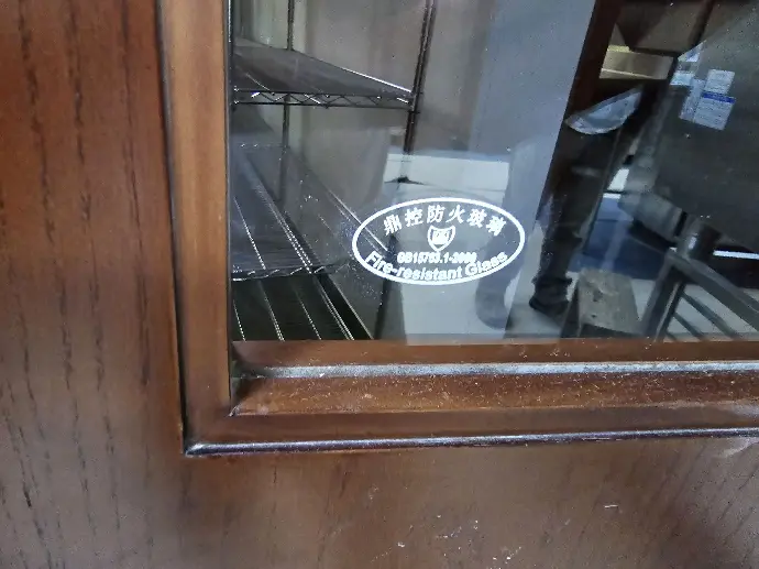 A glass on a door with a label reading: Fire resistant glass