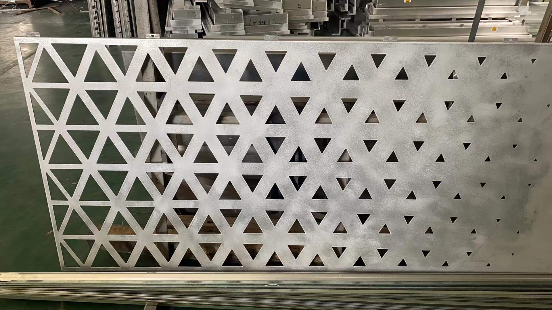 Aluminum facade panel with geometric triangular cutouts.