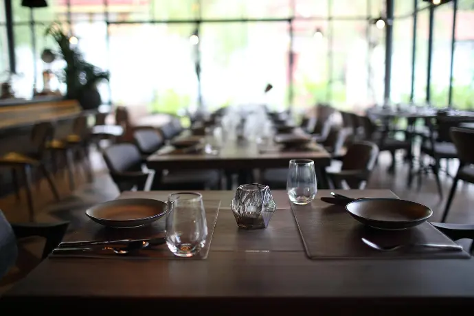  restaurant table with empty plates and utensils, ready for a delicious meal to be served.