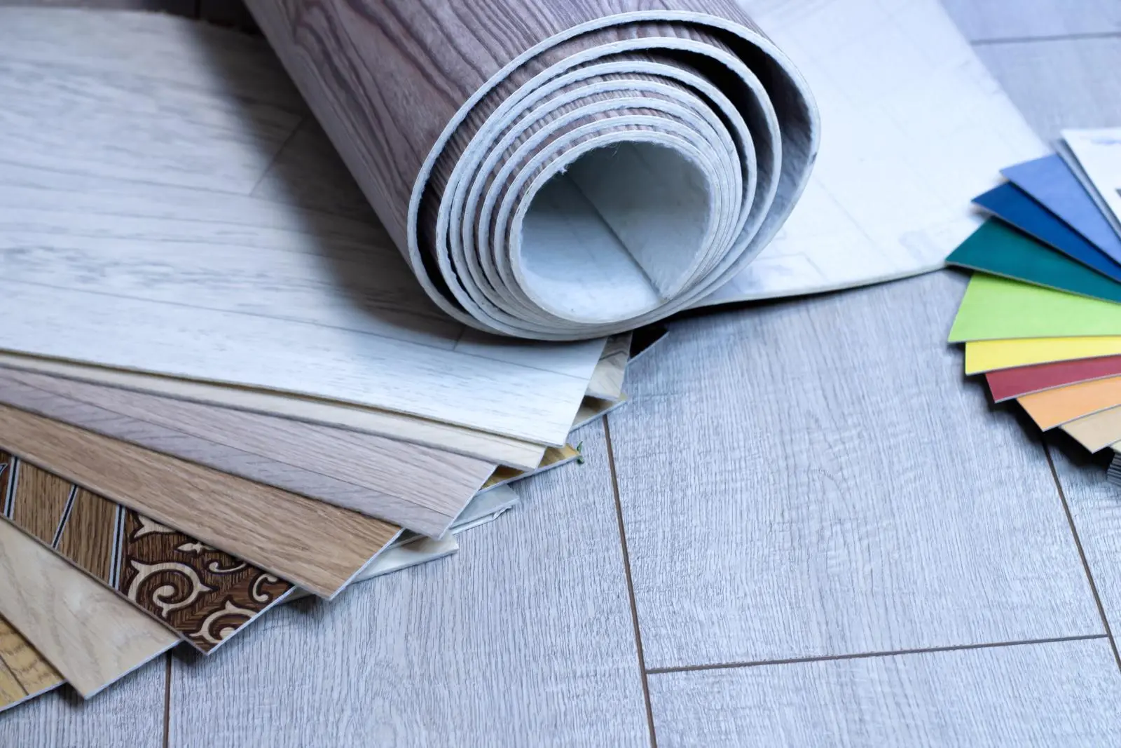 Vinyl Flooring: Affordable and Versatile Flooring Solutions from China A selection of vinyl flooring samples, including rolled sheets and various styles, with color swatches for comparison.