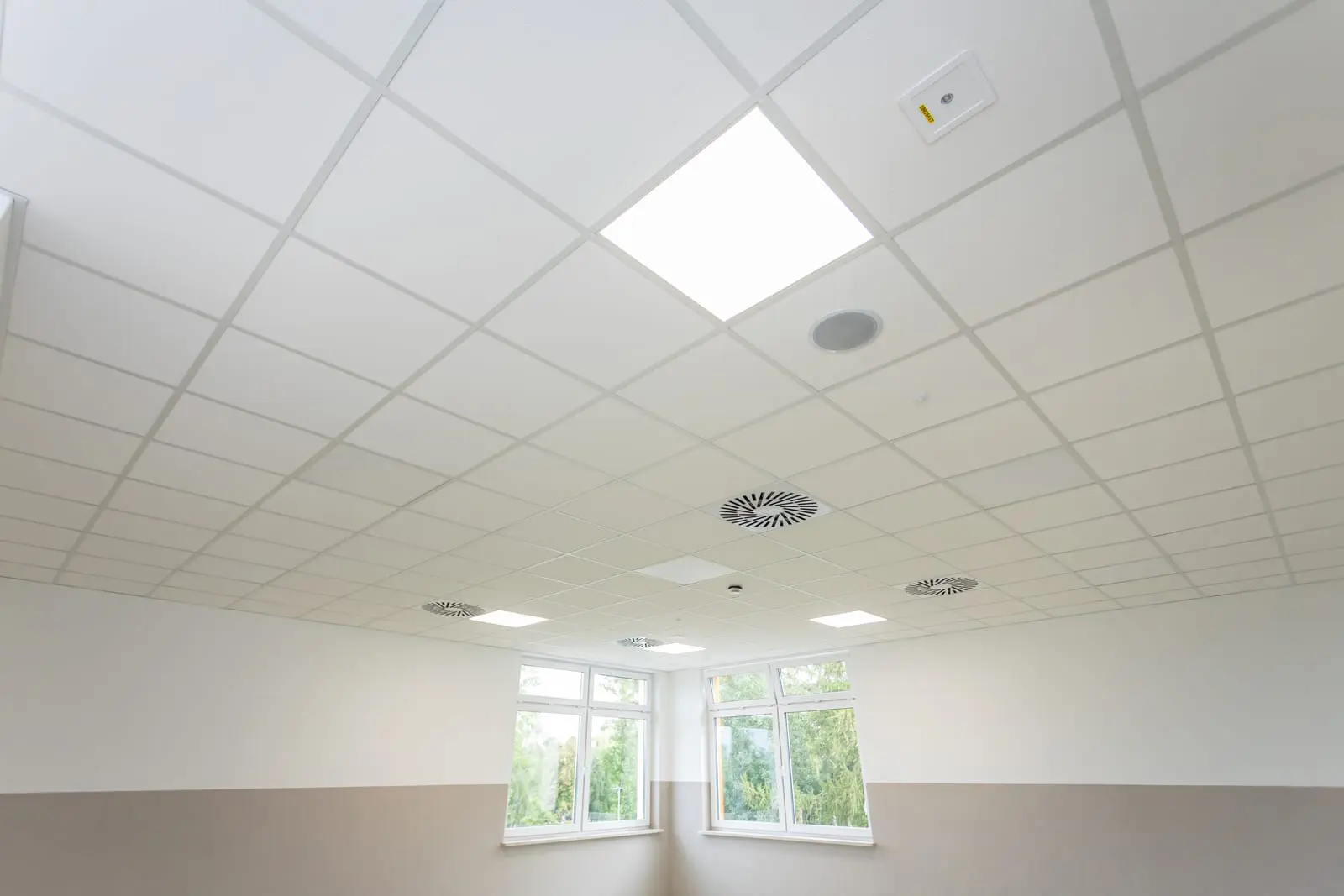 Modern Mineral Fiber Ceiling Tiles with Integrated Lighting and Ventilation Interior view of a ceiling featuring mineral fiber tiles with integrated lighting and ventilation.