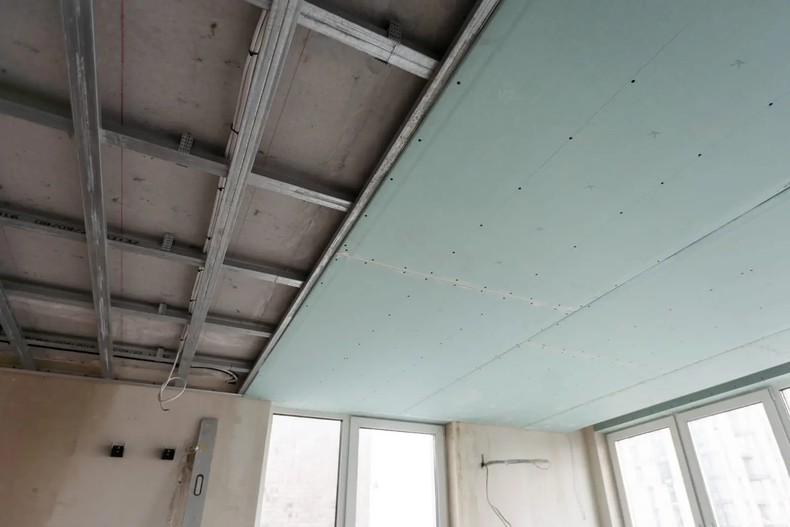 Acoustic Ceiling Systems - Effective Solutions for Noise Reduction and Sound Quality Installation of acoustic ceiling systems with support framework and green panels, designed to reduce noise.