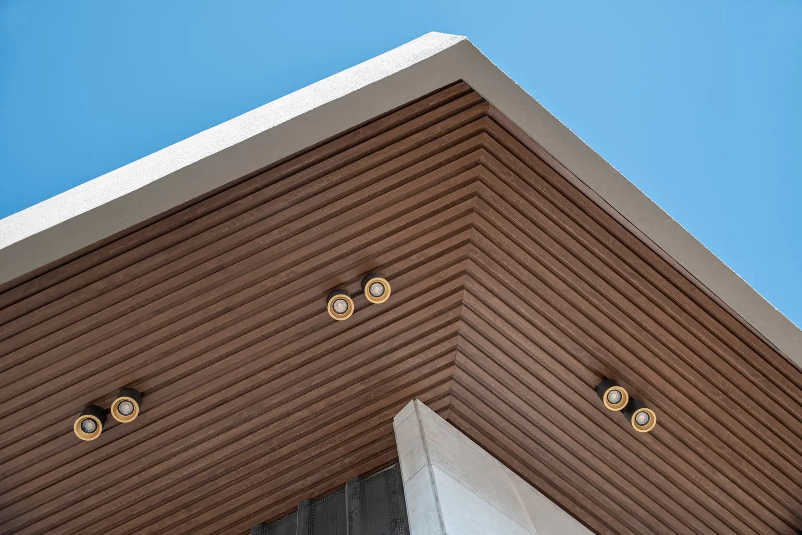 Elegant WPC Ceiling Design with Recessed Lighting and Wooden Textures Close-up of a WPC ceiling featuring horizontal wooden slats and integrated lighting fixtures.