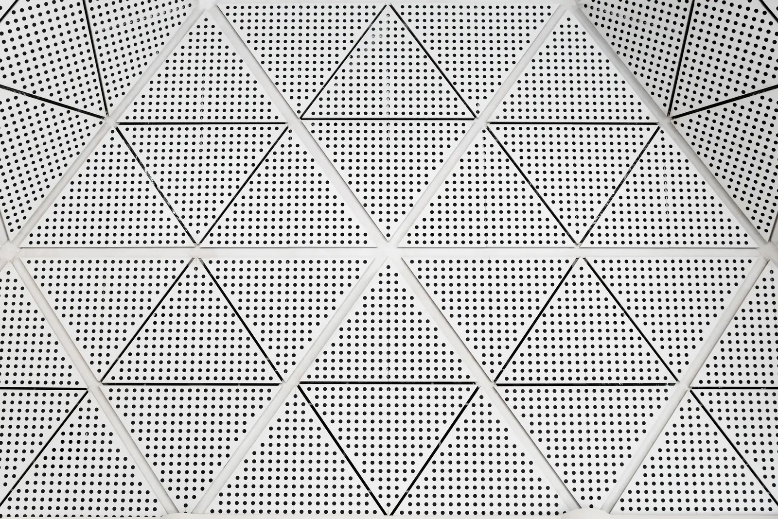 Sleek Aluminum Ceiling Systems with Triangular Perforations Close-up of aluminum ceiling panels featuring triangular perforated design.