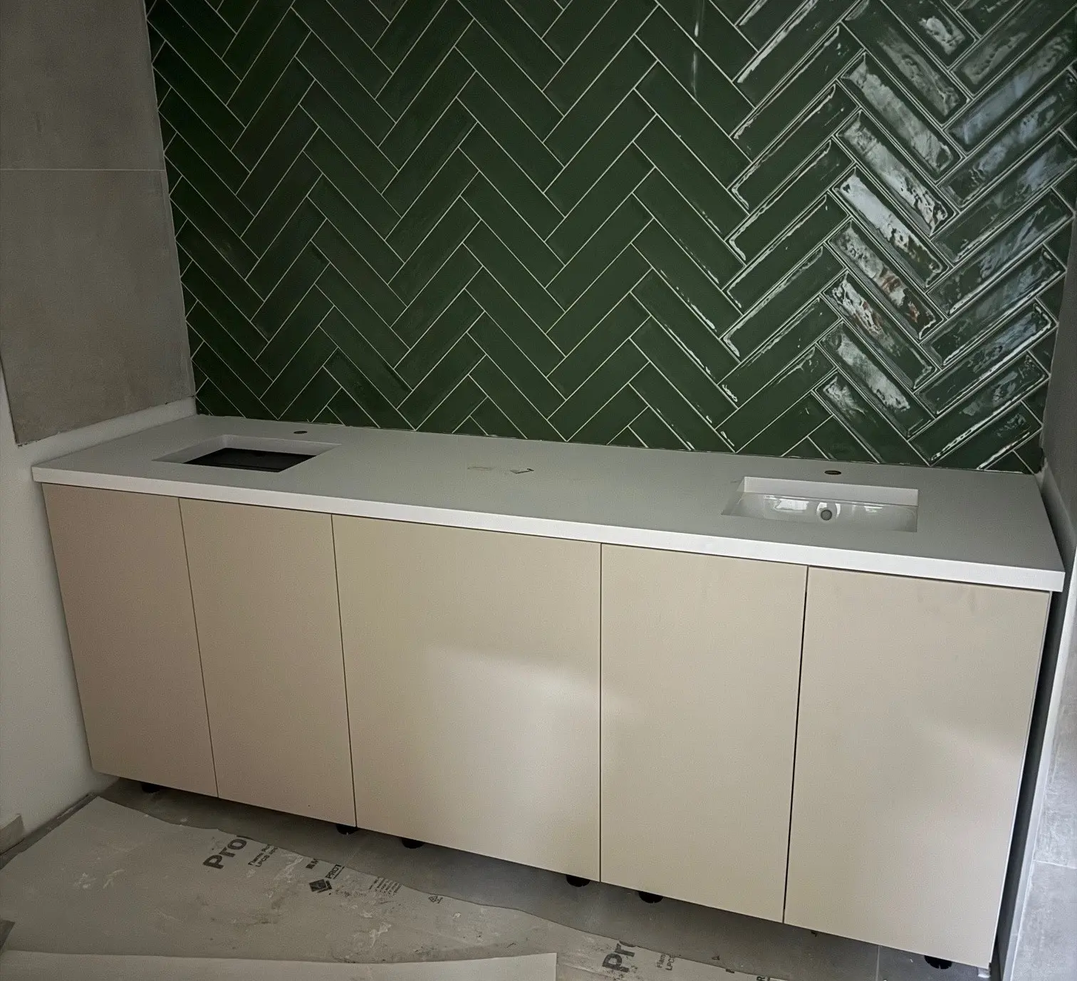 Port Modernization Project - Kitchenette Millwork Solutions in Saint Vincent and the Grenadines Modern kitchenette with beige cabinetry and white countertop, showcasing millwork solutions for the Port Modernization Project in Saint Vincent and the Grenadines.
