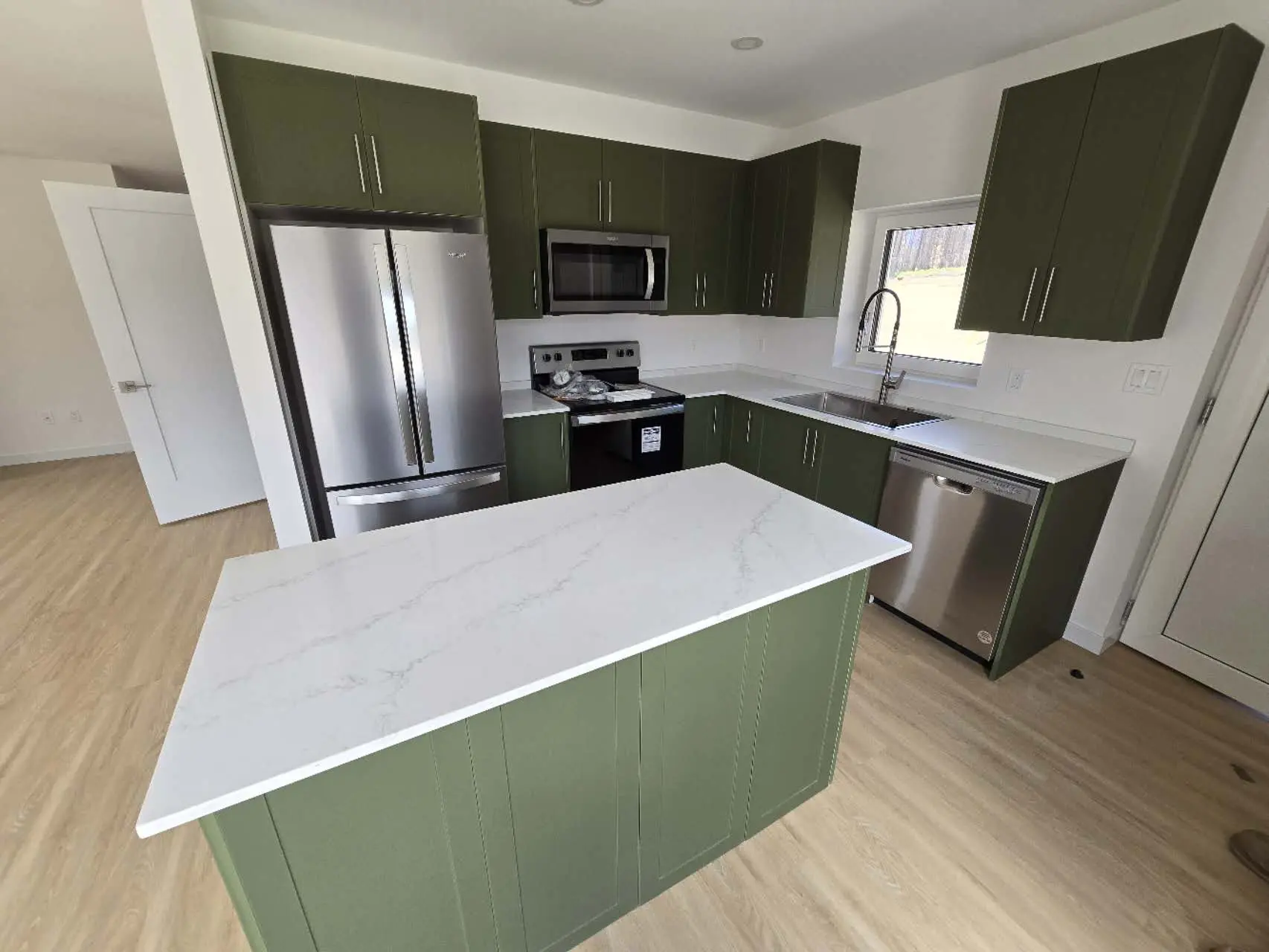 Guangzhou Sourcing Project 2024 - Simpcw First Nation, Canada Stylish modern kitchen with green cabinetry and marble countertops, featuring stainless steel appliances.
